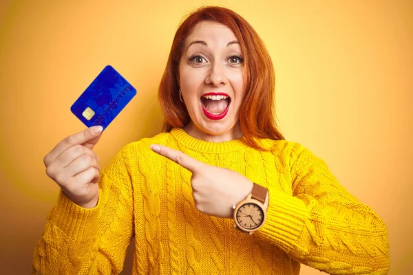 Młody Klient Ruda Kobieta Trzyma Kartę Kredytową Żółtym Odizolowanym Tle — Zdjęcie stockowe