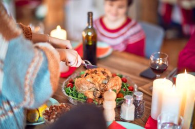Mutlu ve kendinden emin gülümseyen güzel bir aile. Kızarmış hindilerden biri Şükran Günü 'nü evde kutluyor.