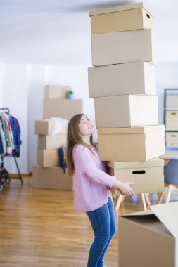 Kutuları olan genç bir kadın yeni eve taşınıyor.