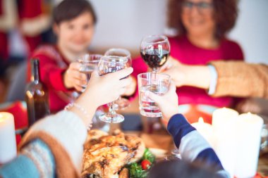 Mutlu ve kendinden emin gülümseyen güzel bir aile. Kızarmış hindi yemek, bir bardak şarapla kadeh kaldırmak Noel 'i evde kutlamak.