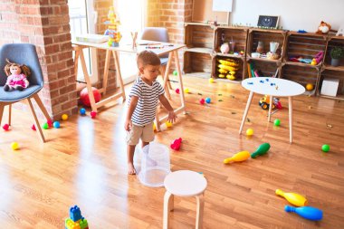 Anaokulunda plastik sepetle oynayan güzel çocuk.