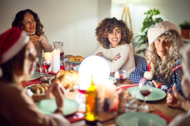 Mutlu ve kendinden emin gülümseyen güzel bir kadın grubu. Evde kızarmış hindi yiyip Noel 'i kutluyoruz.