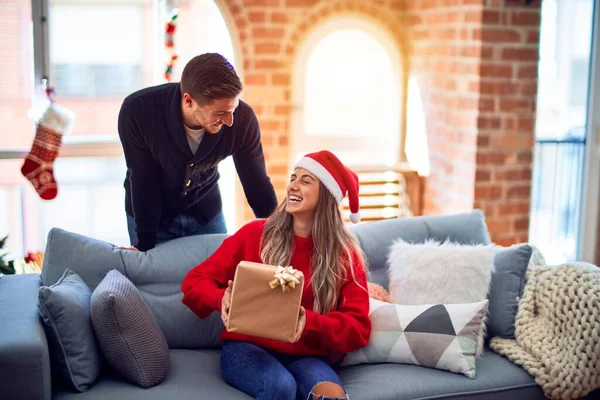 年轻漂亮的夫妇面带微笑 既快乐又自信 男人给家里圣诞树旁的女人一个惊喜 — 图库照片