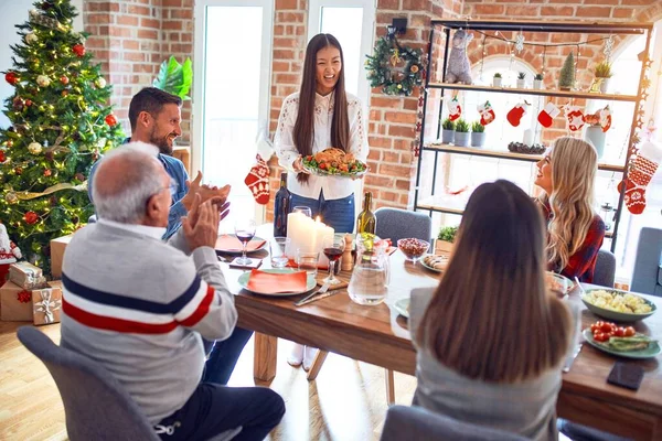 美丽的家庭会面时 面带微笑 快乐而自信 在家里举着烤火鸡庆祝圣诞节的人 — 图库照片