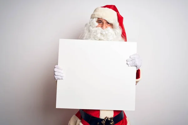 中年男子身穿圣诞老人服装 拿着横幅挂在孤立的白色背景上 脸上挂着幸福的表情 脸上挂着自信的笑容 露出牙齿 — 图库照片