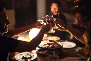 Güzel bir aile terasta bir bardak şarapla kadeh kaldırıyor.