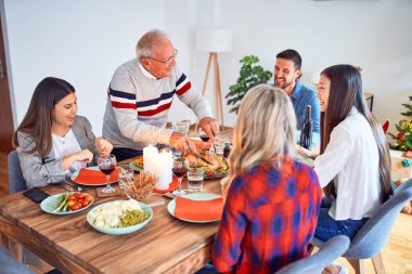 Mutlu ve kendinden emin gülümseyen güzel bir aile toplantısı. Evde Noel 'i kutlamak için fırında hindi pişiriyorum.