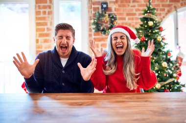 Noel Baba şapkası takan genç bir çift evde Noel ağacının etrafında oturmuş başarının çılgınlığını kutluyor kollarını kaldırmış ve gözlerini kapatmış heyecanlı çığlıklar atıyorlar. Kazanan konsept