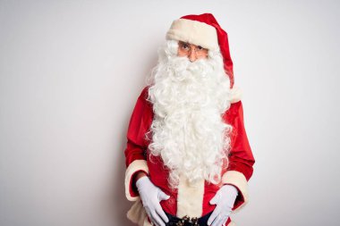 Noel Baba kostümü giyen orta yaşlı yakışıklı adam izole edilmiş beyaz bir arka plan üzerinde duruyor şüpheci ve gergin, sorun yüzünden suratını asıyor. Negatif kişi.