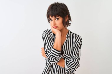 İzole edilmiş beyaz arka plan üzerinde duran çizgili tişört giyen genç ve güzel bir kadın kollarını kavuşturarak depresyondan sıkılmış ve yorgun göründüğünü düşünüyor..