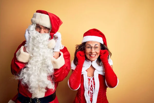 Paar Mittleren Alters Weihnachtsmannkostüm Und Brille Vor Isoliertem Gelben Hintergrund — Stockfoto