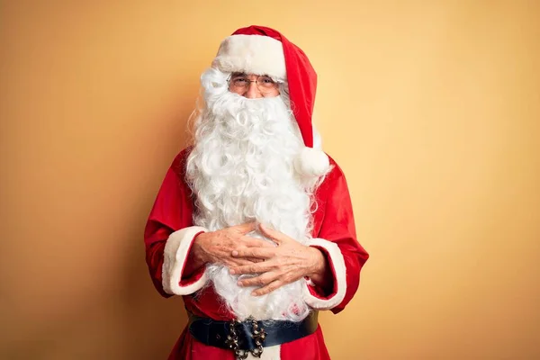 中年英俊男子穿着圣诞老人的服装 站在孤立的黄色背景之上 脸上挂着快乐而凉爽的笑容 幸运的人 — 图库照片