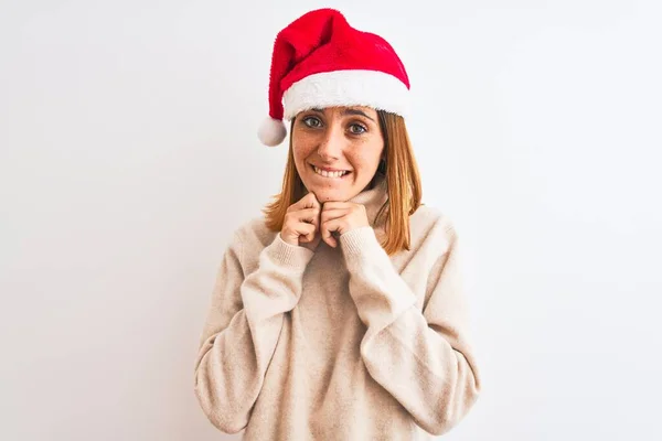 美しいです赤毛女性身に着けていますクリスマス帽子上の隔離された背景笑い神経と興奮で手で顎見ますザ側 — ストック写真