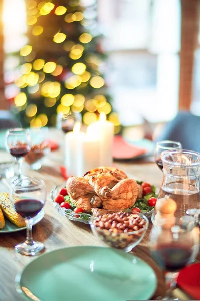 お祝いの休日にクリスマステーブルの設定 木の照明や装飾の周りに七面鳥とおいしい食事と伝統的な食品のフル — ストック写真