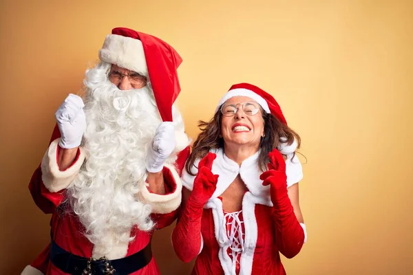 Paar Mittleren Alters Weihnachtsmannkostüm Und Mit Brille Über Gelbem Hintergrund — Stockfoto