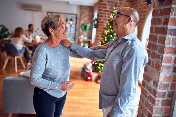 Family and friends dining at home celebrating christmas eve with traditional food and decoration, romantic senior couple talking together happy and casual