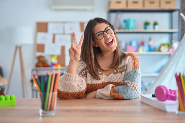 Young Beautiful Teacher Woman Wearing Sweater Glasses Sitting Desk Kindergarten — Stockfoto