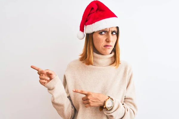 Hermosa Pelirroja Con Sombrero Navidad Sobre Fondo Aislado Señalando Lado —  Fotos de Stock