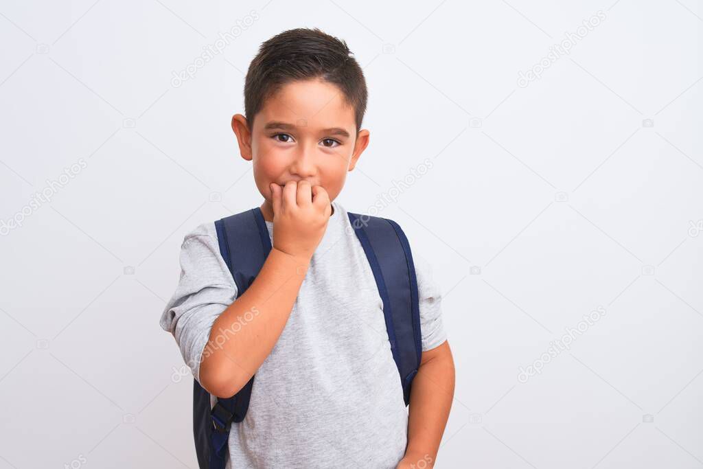 Beautiful student kid boy wearing backpack standing over isolated white background looking stressed and nervous with hands on mouth biting nails. Anxiety problem.