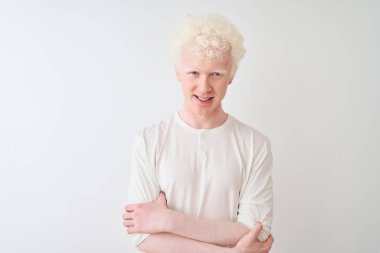 İzole edilmiş beyaz arka plan üzerinde sıradan tişörtler giyen genç, sarışın adam kameraya bakarken çapraz kollarla gülümsüyor. Pozitif kişi.