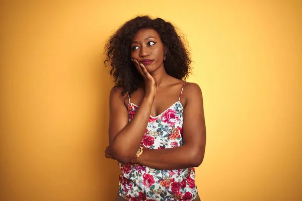 アフリカ系アメリカ人女性身に着けています花夏Tシャツ上の隔離された黄色の背景思考疲れていると退屈でうつ病問題で交差腕 — ストック写真
