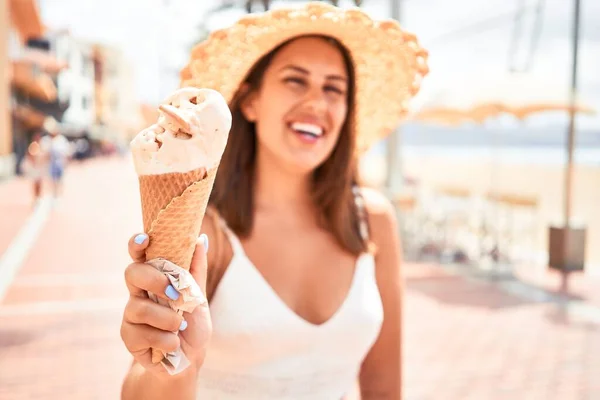 夏の晴れた日の休日にビーチでアイスクリームコーンを食べる若い美しい女性 — ストック写真