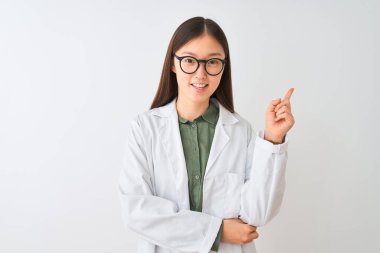 İzole edilmiş beyaz arka plan üzerinde ceket ve gözlük takan Çinli genç bir bilim kadını yüzünde büyük bir gülümsemeyle kameraya el ve parmak ile bakıyor..