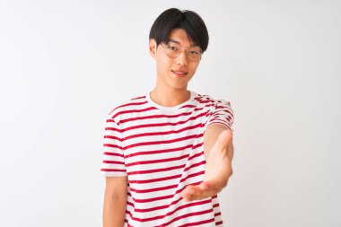 Gözlüklü ve çizgili tişörtlü genç Çinli adam izole edilmiş beyaz arka planda durup dostça selamlaşma ve selamlaşma olarak el sıkışmayı sunuyor. Başarılı bir iş..