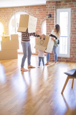 Yeni evde karton bel kutuları ile oynayan çocuk ile güzel famiily