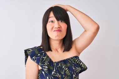 Yazlık çiçekli tişört giyen genç, güzel Çinli bir kadın izole edilmiş beyaz arka planda, elleri başının üstünde, utanç ve şaşkınlık dolu, sinirli ve hayal kırıklığına uğramış bir halde. Hata için korku ve üzüntü.