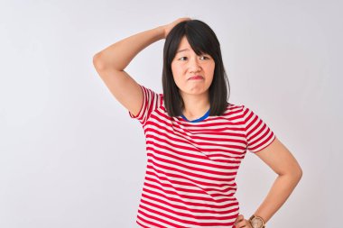 İzole edilmiş beyaz arka plan üzerine kırmızı çizgili tişört giyen genç ve güzel Çinli bir kadın, soru sormayı merak ediyor. Şüpheyle kararsız, kafa kafaya düşünerek. Düşünceli kavram.