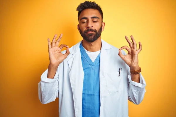 Junger Indischer Arzt Der Vor Isoliertem Gelben Hintergrund Steht Entspannt — Stockfoto