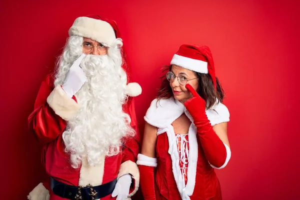 Paar Mittleren Alters Weihnachtsmannkostüm Und Brille Über Isoliertem Rotem Hintergrund — Stockfoto