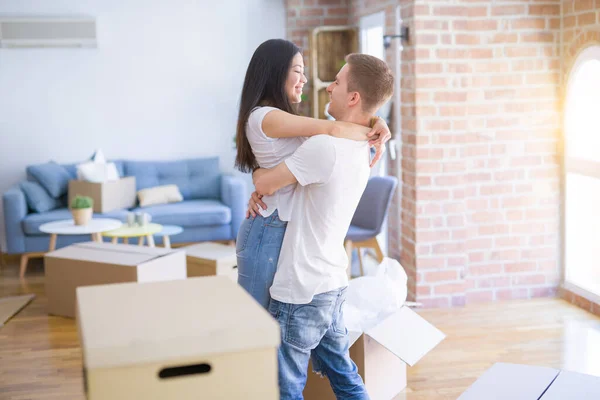 Young Beautiful Couple Hugging New Home Cardboard Boxes — Stock Photo, Image