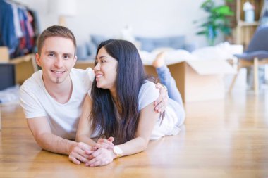 Genç güzel çift karton kutular etrafında yeni evde yatarken