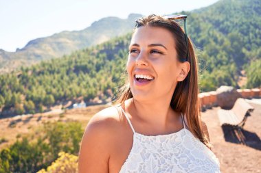 Genç ve güzel bir turist kadın gülümsüyor. Yaz tatilinin tadını çıkarıyor.