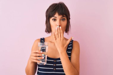 Genç ve güzel bir kadın, pembe arka plandaki izole edilmiş bir bardağın başında dikiliyordu. Ağzını kapatıyordu. Yanlışlıktan dolayı utanmıştı, korkmuştu, sessizlikten korkmuştu.