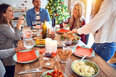 Mutlu ve kendinden emin gülümseyen güzel bir aile toplantısı. Evde Noel 'i kutlamak için fırında hindi pişiriyorum.