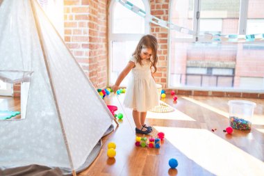 Anaokulunda oyuncak oyuncaklarıyla oynayan sevimli sarışın çocuk.