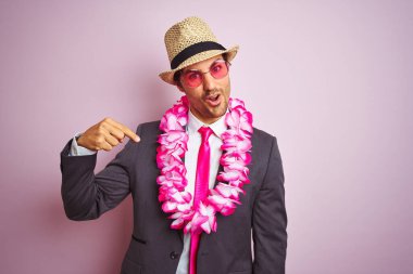 Takım elbiseli genç işadamı gözlüklü Hawai leyleği soyutlanmış pembe arka planda kendini işaret eden sürpriz bir yüz.