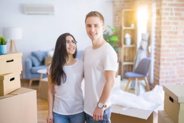 Karton kutuların etrafında duran genç ve güzel bir çift.