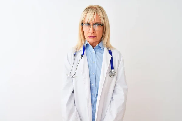 中年妇女医生 戴着眼镜和听诊器 在孤立的白色背景下 持怀疑和紧张的态度 因问题而皱眉 消极的人 — 图库照片