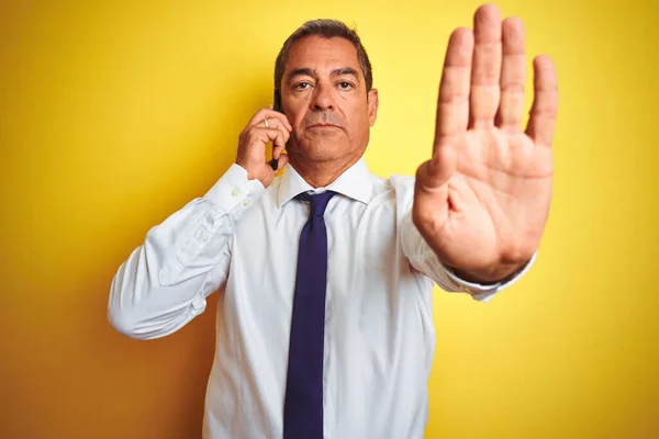 Középkorú Üzletember Beszél Okostelefonon Elszigetelt Sárga Háttér Nyitott Kézzel Csinál — Stock Fotó