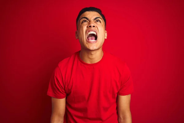 年轻的巴西男子穿着T恤站在孤立的红色背景愤怒和疯狂的尖叫沮丧和愤怒 愤怒地大喊大叫 愤怒和侵略性的概念 — 图库照片