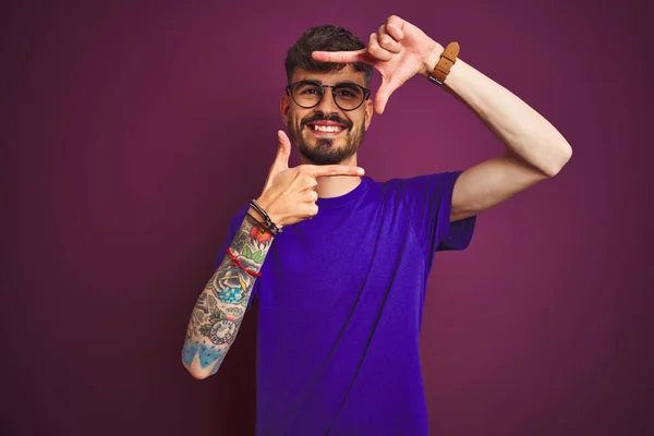 Młody Człowiek Tatuażem Koszulce Okularach Stojący Nad Odizolowanym Fioletowym Tłem — Zdjęcie stockowe
