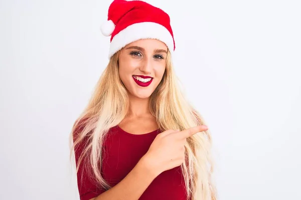 若いです美しい女性身に着けていますクリスマスサンタ帽子上の孤立した白い背景陽気に笑顔で顔を指して手と指で側に幸せと自然な表現で顔 — ストック写真