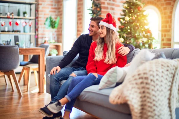 Junges Paar Mit Weihnachtsmann Hut Das Hause Auf Dem Sofa — Stockfoto