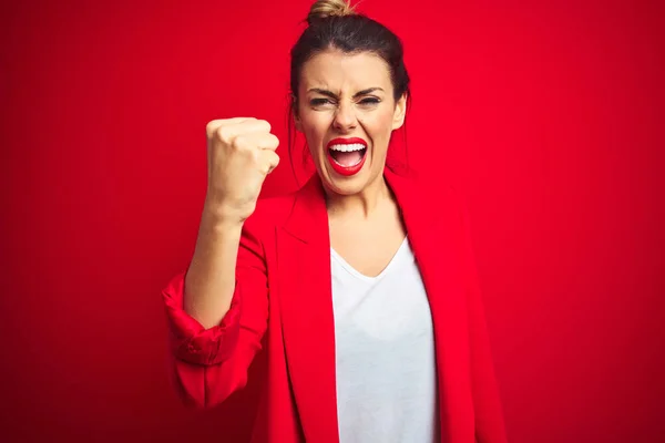 怒りながら大声で叫びながら 赤い孤立した背景に立っている若い美しいビジネス女性は怒りと怒りの拳を上げる 激怒と積極的な概念 — ストック写真