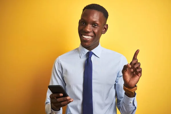 Afroamerikansk Affärsman Med Smartphone Stående Över Isolerad Gul Bakgrund Mycket — Stockfoto