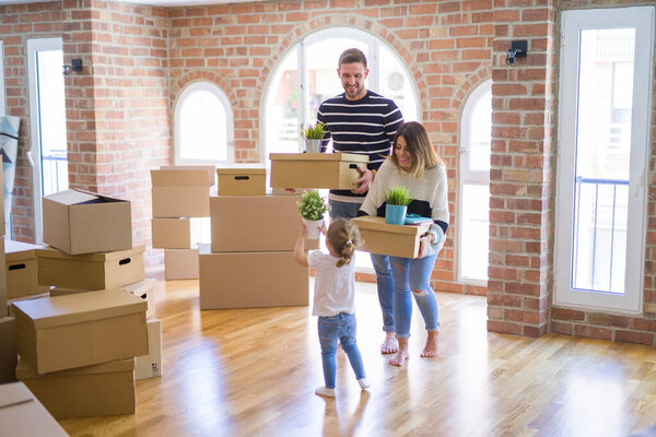 Beautiful famiily, kid playing with his parents riding cardboard fanny box at new home